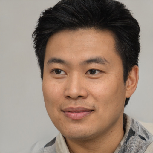 Joyful asian adult male with short  black hair and brown eyes