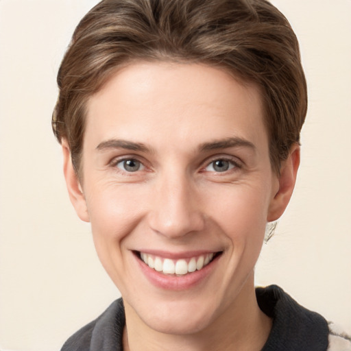 Joyful white young-adult female with short  brown hair and grey eyes