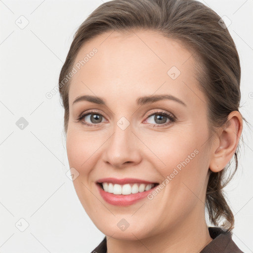 Joyful white young-adult female with medium  brown hair and grey eyes