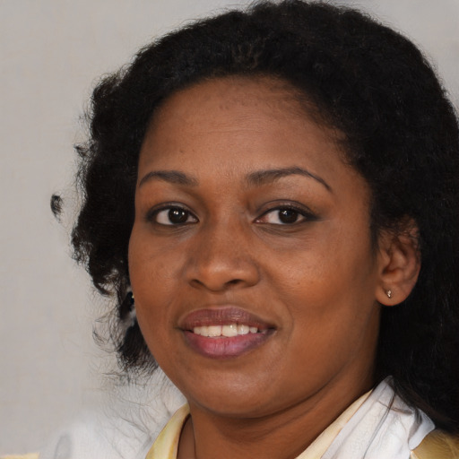 Joyful black adult female with long  black hair and brown eyes