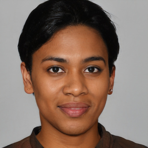 Joyful black young-adult female with short  black hair and brown eyes