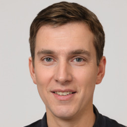 Joyful white young-adult male with short  brown hair and grey eyes