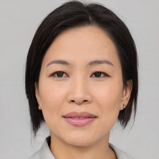 Joyful asian young-adult female with medium  black hair and brown eyes
