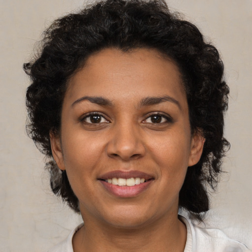 Joyful black young-adult female with short  brown hair and brown eyes