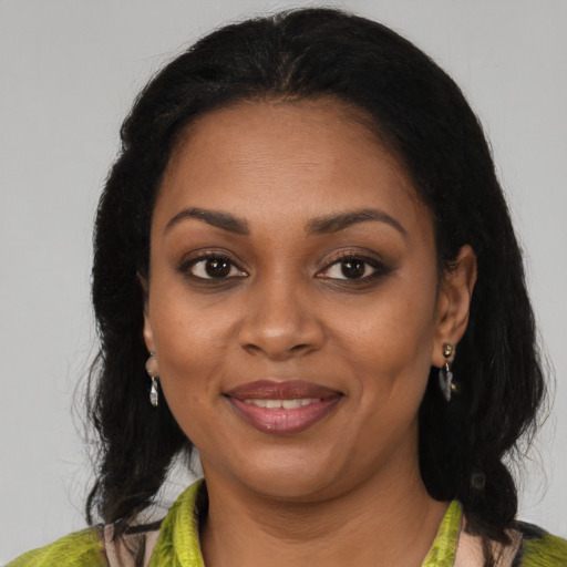 Joyful black adult female with medium  brown hair and brown eyes