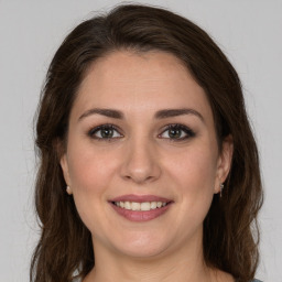 Joyful white young-adult female with long  brown hair and brown eyes