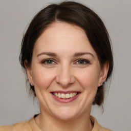 Joyful white adult female with medium  brown hair and brown eyes