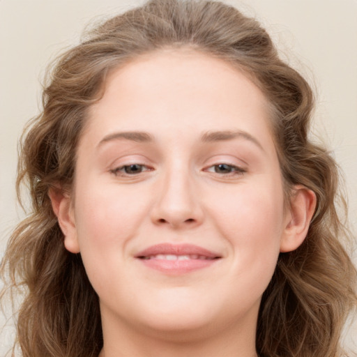 Joyful white young-adult female with long  brown hair and blue eyes