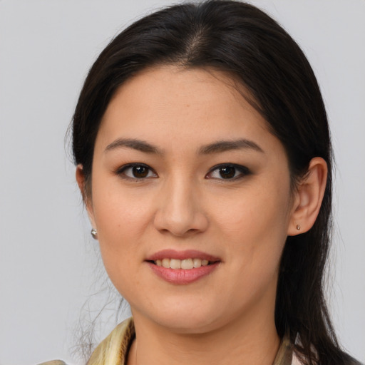 Joyful latino young-adult female with long  brown hair and brown eyes