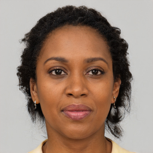 Joyful black adult female with long  brown hair and brown eyes