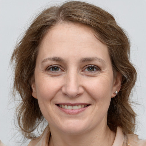 Joyful white adult female with medium  brown hair and grey eyes