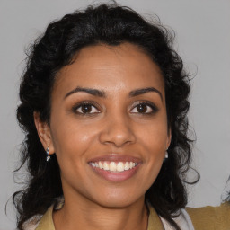 Joyful black young-adult female with medium  brown hair and brown eyes