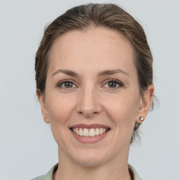 Joyful white adult female with medium  brown hair and grey eyes