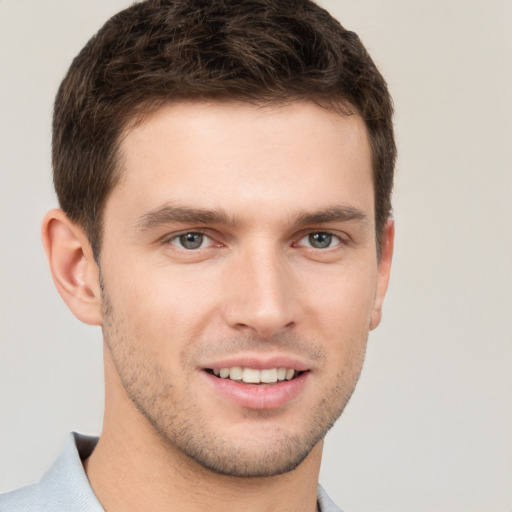 Joyful white young-adult male with short  brown hair and grey eyes