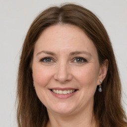 Joyful white adult female with long  brown hair and grey eyes