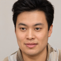 Joyful asian young-adult male with short  brown hair and brown eyes