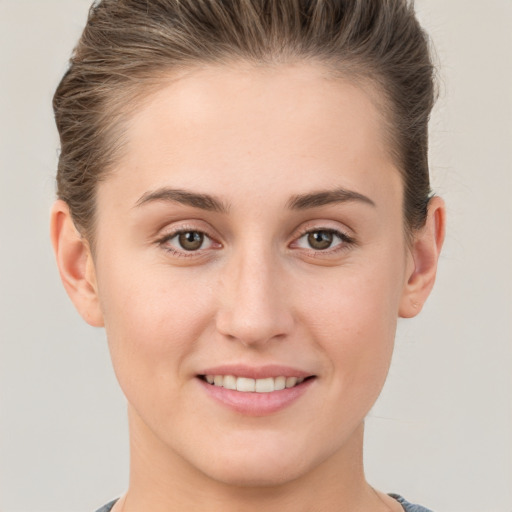 Joyful white young-adult female with short  brown hair and grey eyes