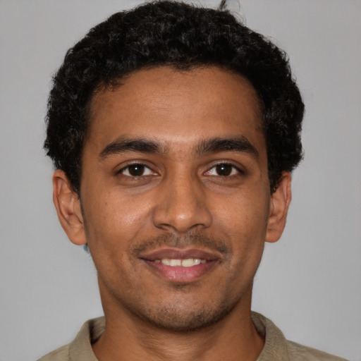 Joyful black young-adult male with short  black hair and brown eyes