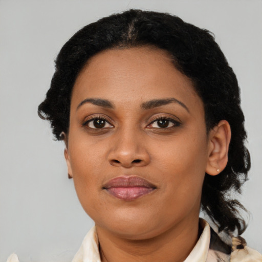 Joyful black young-adult female with short  brown hair and brown eyes