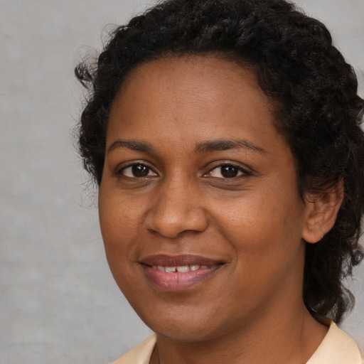 Joyful black young-adult female with medium  brown hair and brown eyes