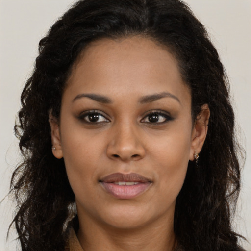Joyful black young-adult female with long  brown hair and brown eyes