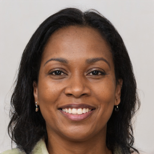 Joyful black adult female with long  brown hair and brown eyes