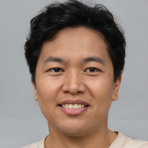 Joyful asian adult male with short  brown hair and brown eyes