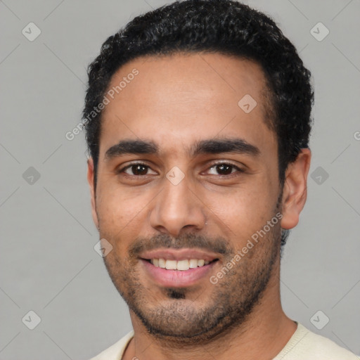 Joyful latino young-adult male with short  black hair and brown eyes