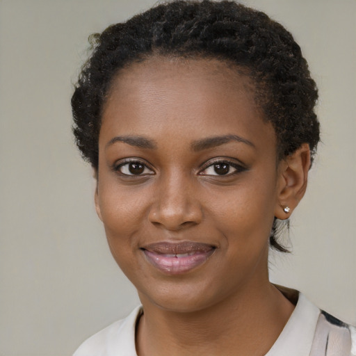 Joyful black young-adult female with short  black hair and brown eyes