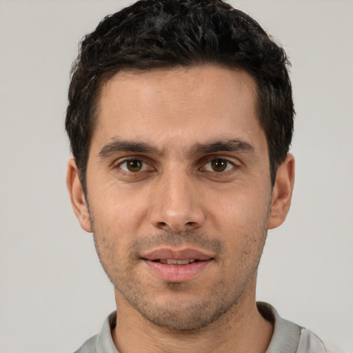 Joyful white young-adult male with short  black hair and brown eyes