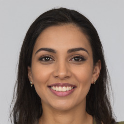 Joyful latino young-adult female with long  brown hair and brown eyes