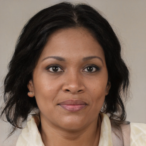 Joyful black adult female with medium  brown hair and brown eyes