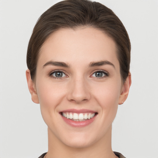 Joyful white young-adult female with short  brown hair and grey eyes