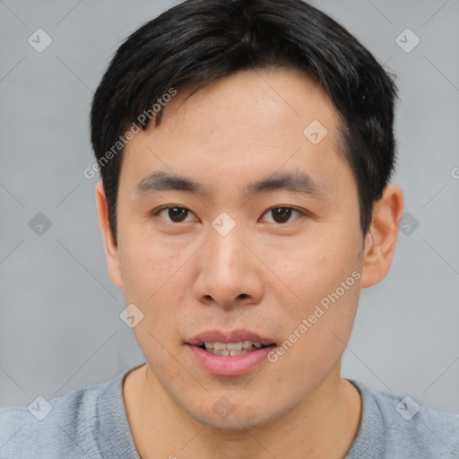 Joyful asian young-adult male with short  brown hair and brown eyes