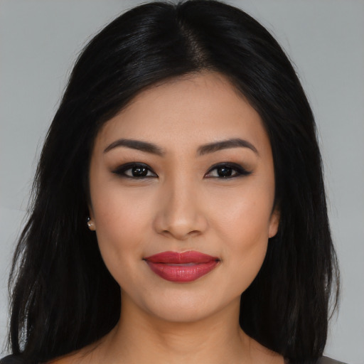 Joyful latino young-adult female with long  black hair and brown eyes