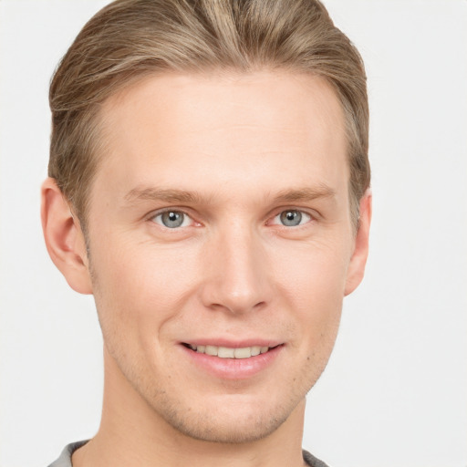 Joyful white young-adult male with short  brown hair and grey eyes