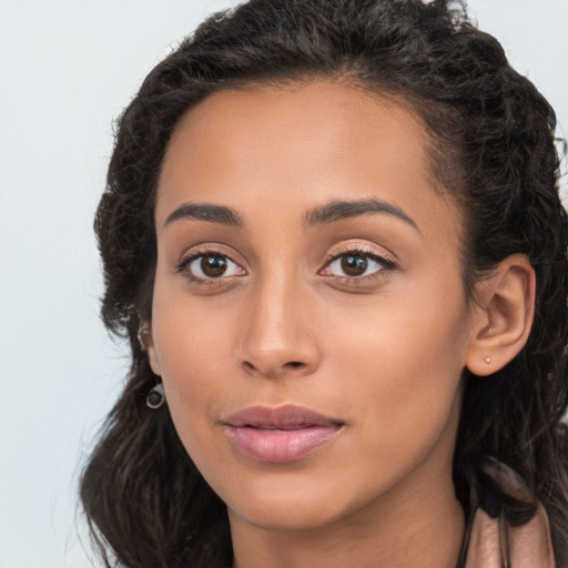 Joyful latino young-adult female with long  brown hair and brown eyes