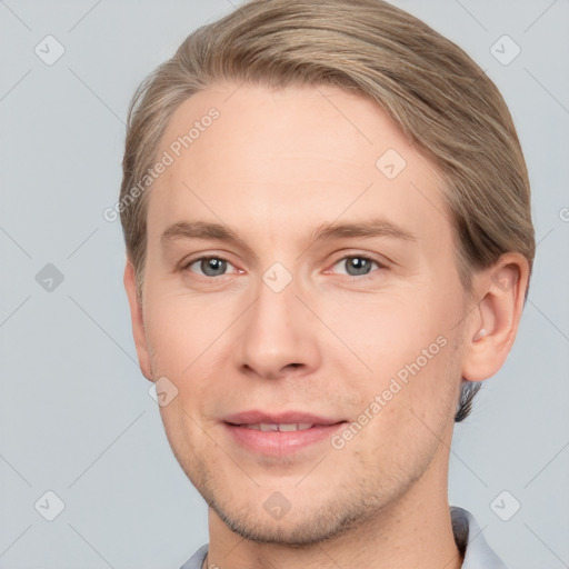 Joyful white young-adult male with short  brown hair and grey eyes