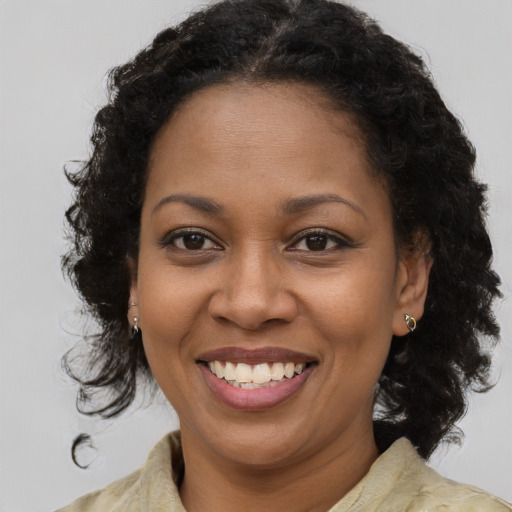 Joyful black adult female with long  brown hair and brown eyes