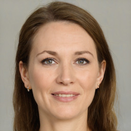 Joyful white adult female with long  brown hair and grey eyes