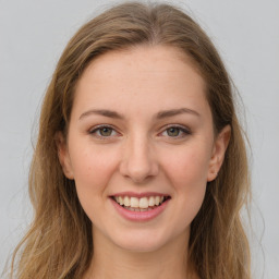 Joyful white young-adult female with long  brown hair and green eyes