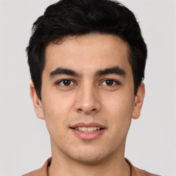 Joyful latino young-adult male with short  black hair and brown eyes