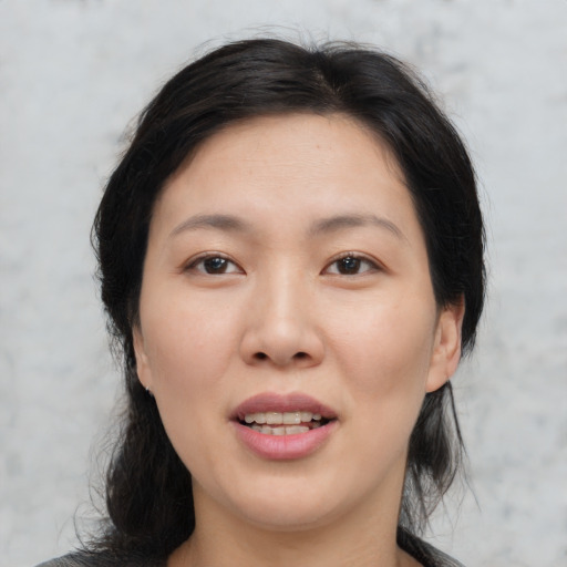 Joyful asian young-adult female with medium  brown hair and brown eyes