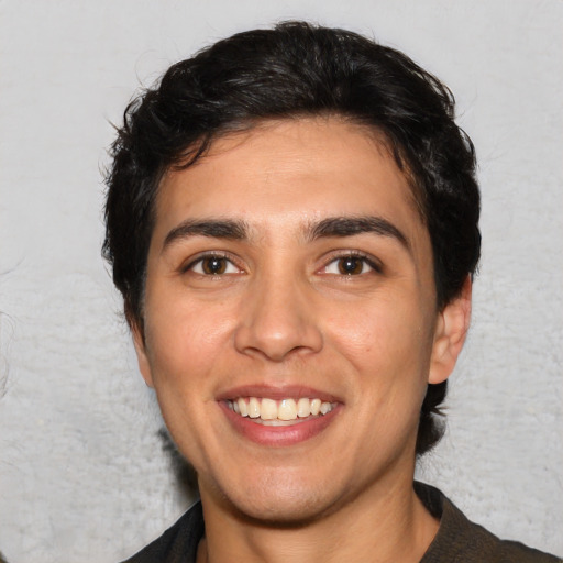 Joyful white young-adult male with medium  black hair and brown eyes