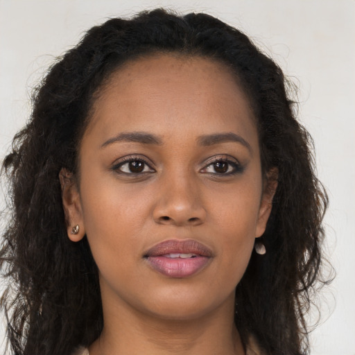 Joyful black young-adult female with long  brown hair and brown eyes