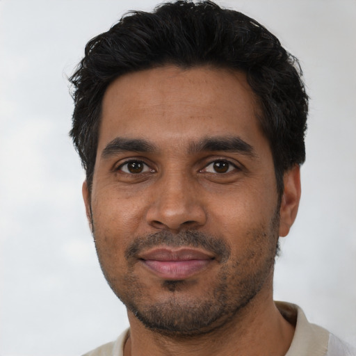 Joyful black young-adult male with short  black hair and brown eyes