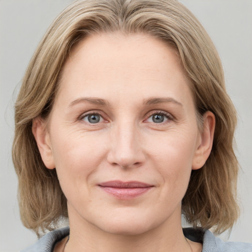 Joyful white adult female with medium  brown hair and blue eyes