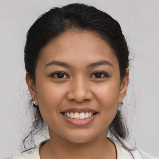 Joyful latino young-adult female with medium  brown hair and brown eyes