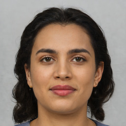 Joyful latino young-adult female with medium  brown hair and brown eyes