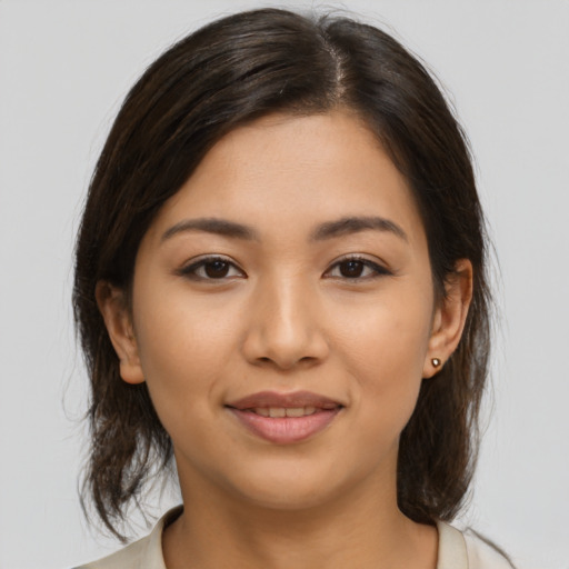 Joyful latino young-adult female with medium  brown hair and brown eyes